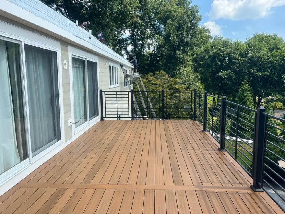 Composite deck renovation with NewTechWood flooring and Fortress railing system on an elevated outdoor space.