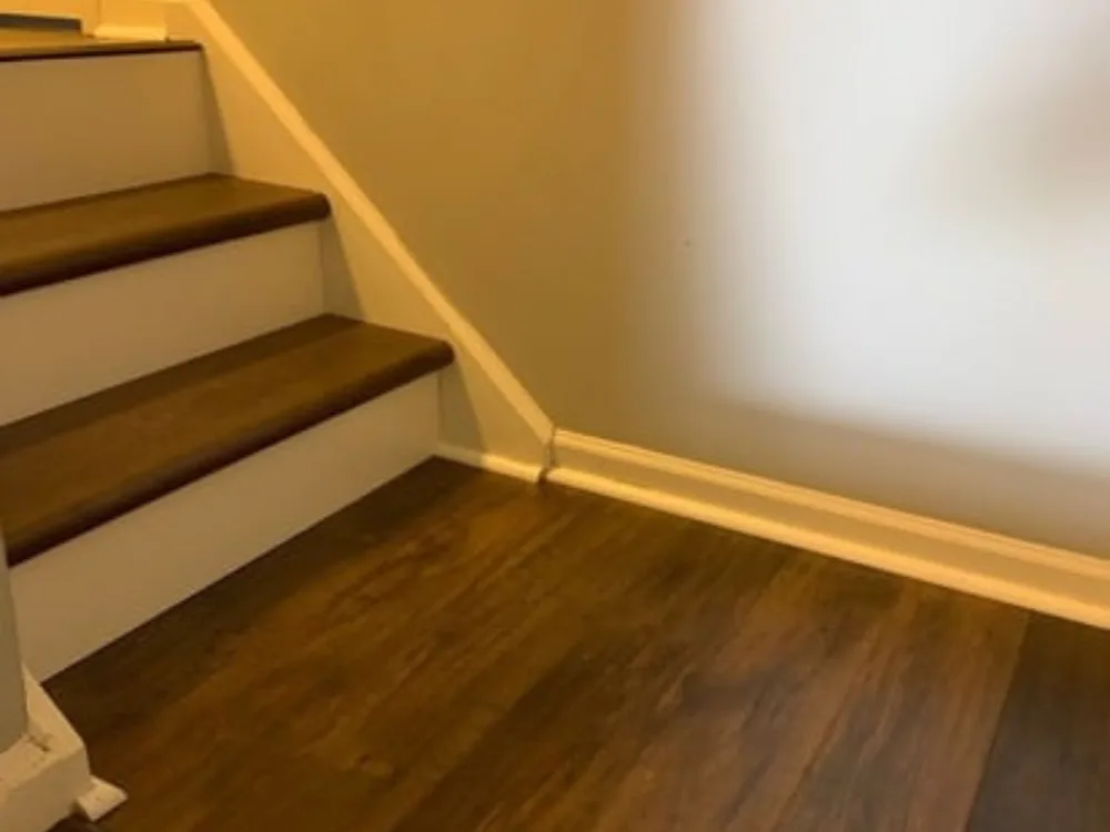 Finished staircase with hardwood flooring and risers.