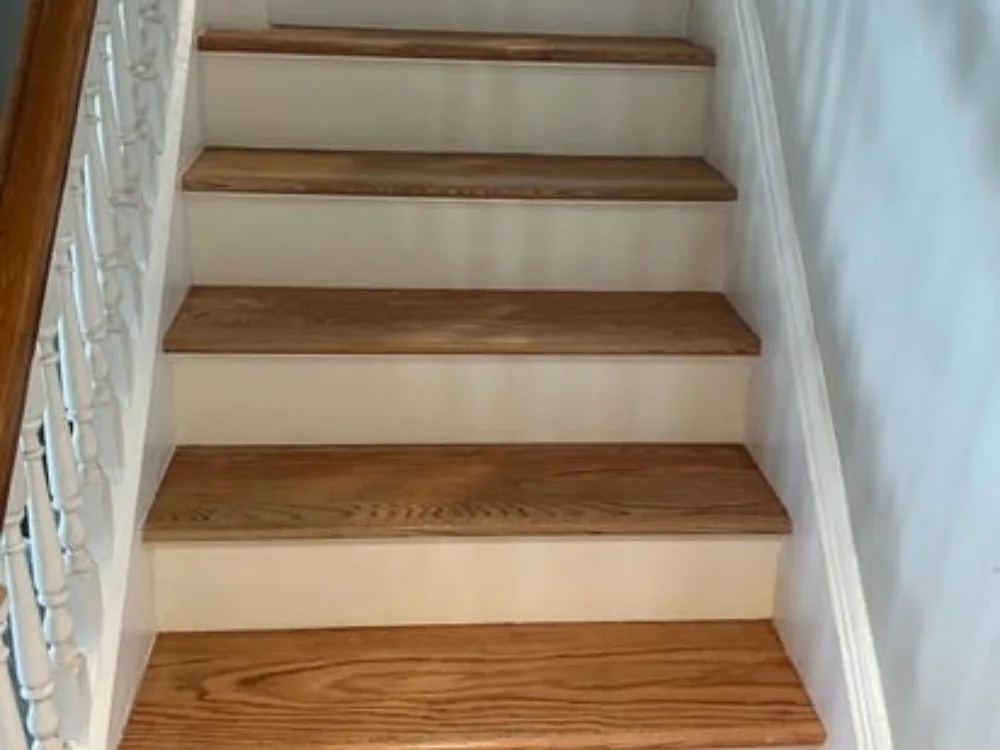 Renovated staircase with new hardwood treads and painted white risers.